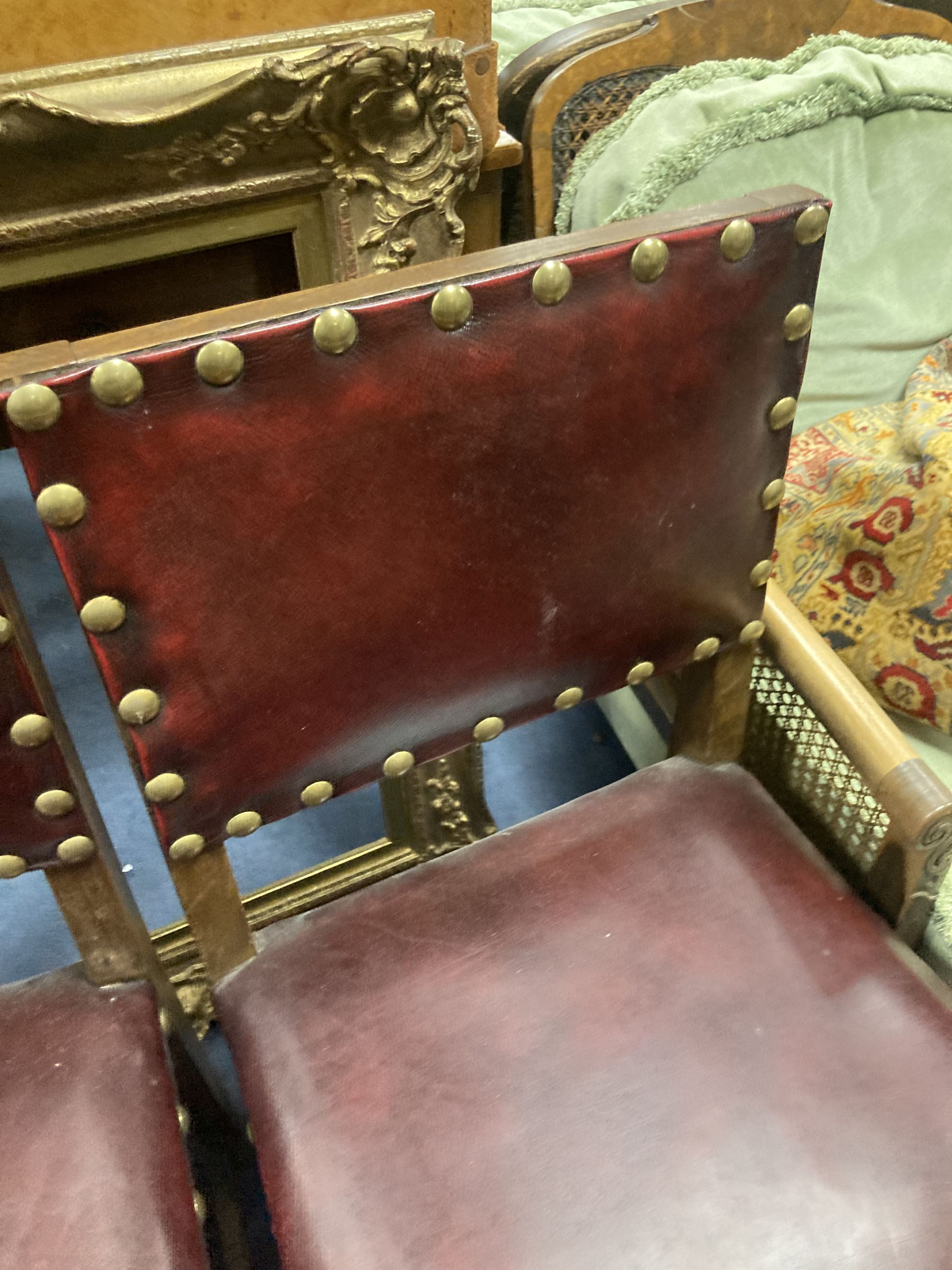 A pair of oak carolean-style dining chairs circa 1880, red leather and studding